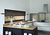 Elegant fitted kitchen with wooden worksurface and stainless steel splashback