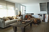 Rustic wooden coffee table, pale sofa and chaise on mezzanine level