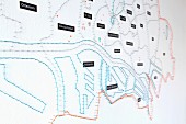 Stadtplan Hamburg stilisiert mit Nägeln und bunten Fäden bespannt an weißer Wand