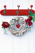 Wreath of seashells decorated with zinnia, dahlia and snap dragon hung on vintage coat rack