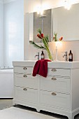 Advent bouquet of amaryllis on washstand in white bathroom