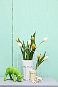 Easter arrangement in pastel shades; tulips in beakers and lamb ornament