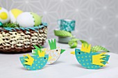 Easter arrangement in yellow and green; colourful, paper chicks as place cards