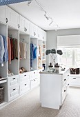 Feminine dressing room with open-fronted white wardrobes