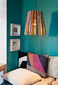 Upcycling - pendant lamp made from wooden rods above patchwork cushions