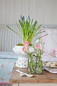 Spring arrangement of grape hyacinths and ranunculus on old table