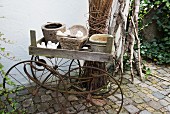 Various planters in wooden crate on antique pram frame