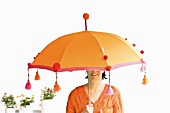 Woman under orange Balinese parasol