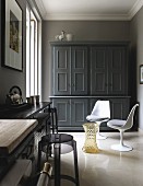 Kitchen with plastic retro chairs in front of country-house-style cupboard painted grey