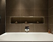 Braun gefliestes Badezimmer mit Ablagenische über der Badewanne