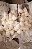 White meringues on vintage-style paper on cake stand