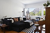 Schwarze Couchkombination und antike Stühle in modernem Wohnzimmer