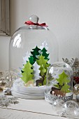Hand-crafted Christmas scenes with felt Christmas trees and reindeer under glass covers