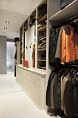 Jackets on clothes racks and drawers in walk-in wardrobe