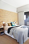 Partially wood-clad wall in bedroom