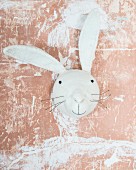 Felt rabbit against wall with dusky pink patinated paint