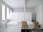Schlafbereich mit Dielenboden und weiss gestrichener Ziegelwand, im Hintergrund Raumteiler