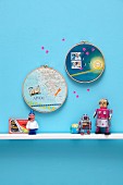 Souvenirs: maps and postage stamps in embroidery hoops decorating wall