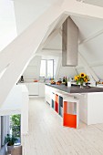 Island counter and designer stools with brightly painted inner surfaces in attic kitchen