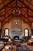 Grand, high-ceilinged, country-house interior with historical ambiance, stone fireplace and exposed rood structure