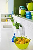 Shades of blue and green in wall cabinet and on sink unit of white kitchen counter