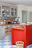 Red-painted island counter opposite grey, county-house-style kitchen counter