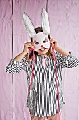 Smiling girl holding hand-crafted rabbit mask