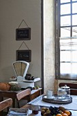 Antique scales, lattice window and fruit bowl on wooden table in Mediterranean kitchen