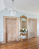 Antique furniture, two panelled doors and old wooden floor in foyer