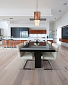 Black dining table and cantilever chairs in open-plan kitchen-dining area
