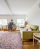 Fifties-style lime-green sofa, multicoloured rug and desk in background
