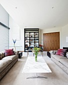 Grey Chesterfield sofas and marble coffee table in spacious living room