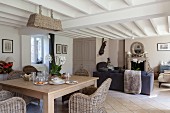 Wicker furniture in open-plan living-dining area of renovated farmhouse