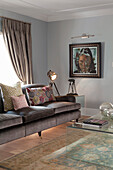 Dark grey velvet sofa with cushions and floor lamp in the grey-painted living room