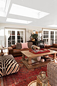 Living room with leather sofa set, red oriental carpet and solid wooden table