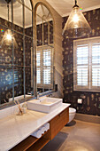 Bathroom with wall mirror and patterned wallpaper