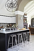 Kitchen with large island and bar stools and modern chandelier