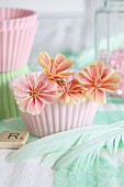 Romantic arrangements of pastel flowers in pink silicon cake case and turquoise feathers