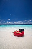 Woman relaxing on beanbag on Maldives beach