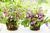 Posies of aquilegia and lady's mantle in DIY vases wrapped in moss