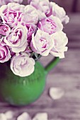 Ein Strauß rosa Rosen in Keramikkrug