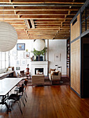 Wooden floor and wood-beamed ceiling in vintage-style open-plan interior