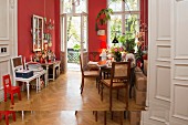 Vintage furnishings in period living room with red walls and herringbone parquet floor