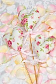 Floral, fabric love-hearts on wooden sticks as wedding decorations