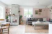 Corner couch, coffee table and fireplace in living room with pastel pink walls