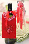 Hand-crafted, festive, felt bottle collar on wine bottle as drip catcher