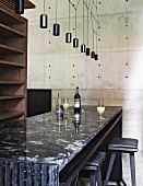 Black granite counter, empty wooden shelves and concrete wall