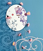 Round mirror with butterfly motifs and floral fairy lights on blue wall