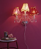 Vintage-style crystal wall lamp with fabric lampshades on pink wall