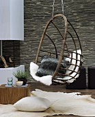 Cosy cushion and sheepskin in hanging chair in cosy seating area in living room